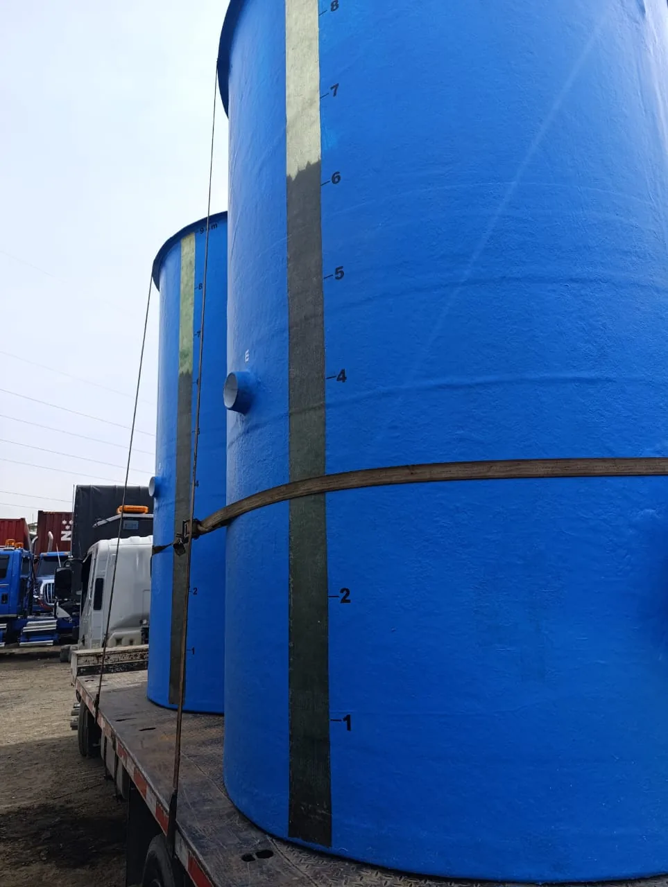 Tanques verticales azules con la escala graduada rotulada, asegurados sobre la cama de un camión.